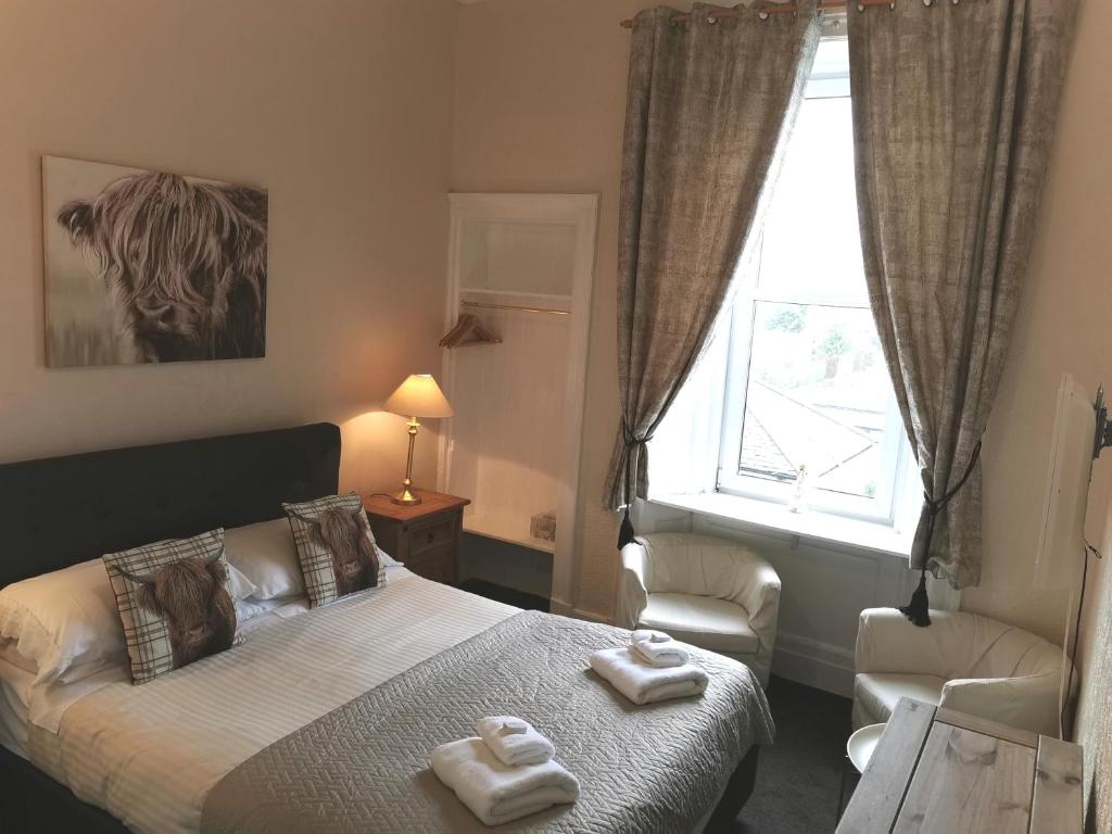 um quarto com uma cama com duas toalhas em Brig O'Doon Guest House em Edimburgo