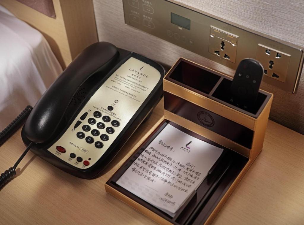 ein Telefon und ein Tablet auf einem Schreibtisch in der Unterkunft Lavande Hotel Nanchang Hongdu Middle Avenue Provincial TV Station Branch in Nanchang