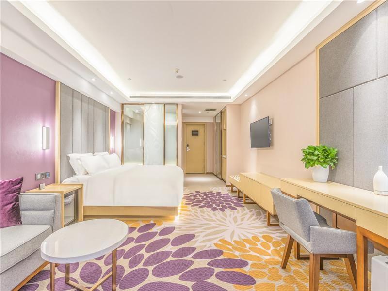 une chambre d'hôtel avec un lit, une table et des chaises dans l'établissement Lavande Hotel Langfang Dacheng Xinda Xintiandi Plaza, à Daicheng