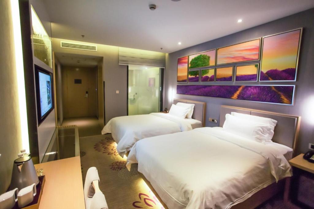 a hotel room with two beds and a painting on the wall at Lavande Hotel Xuzhou East High-speed Rail Station Jinshanqiao Development Zone Branch in Xuzhou
