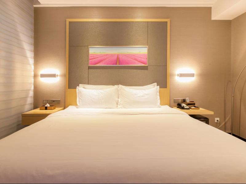 een groot wit bed in een hotelkamer bij Lavande Hotel Wuhan Xudong Branch in Wuhan