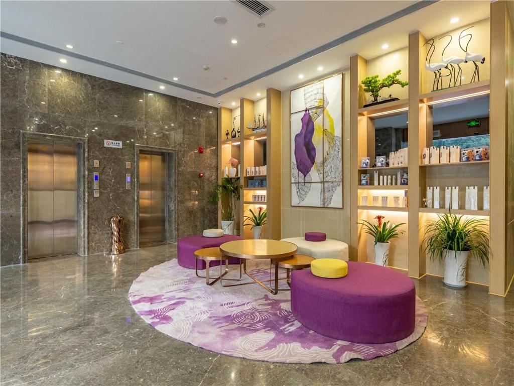 a lobby with purple furniture and a table and chairs at Lavande Hotel(Nanchang Qingshan Road Subway Station Branch) in Nanchang