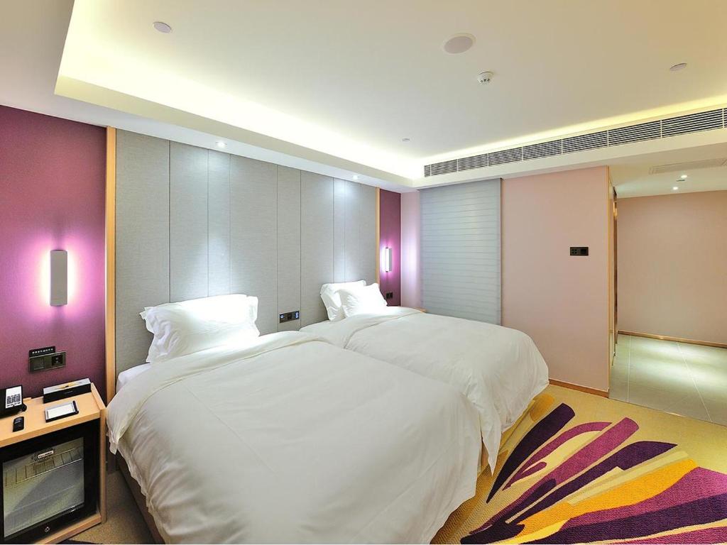 a hotel room with two beds and a tv at Lavande Hotel (Siping Wanda Plaza Branch) in Siping