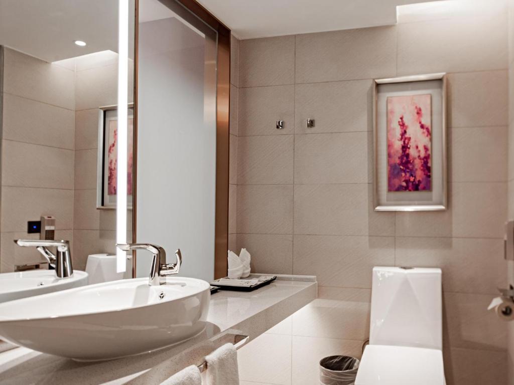 a white bathroom with a sink and a mirror at Lavande Hotel Changsha Avenue Metro Station in Changsha
