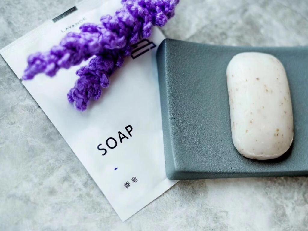 a piece of paper with a soap next to a purple flower at Lavande Hotel (Nanchang Qingshan Lake High-tech Branch) in Nanchang
