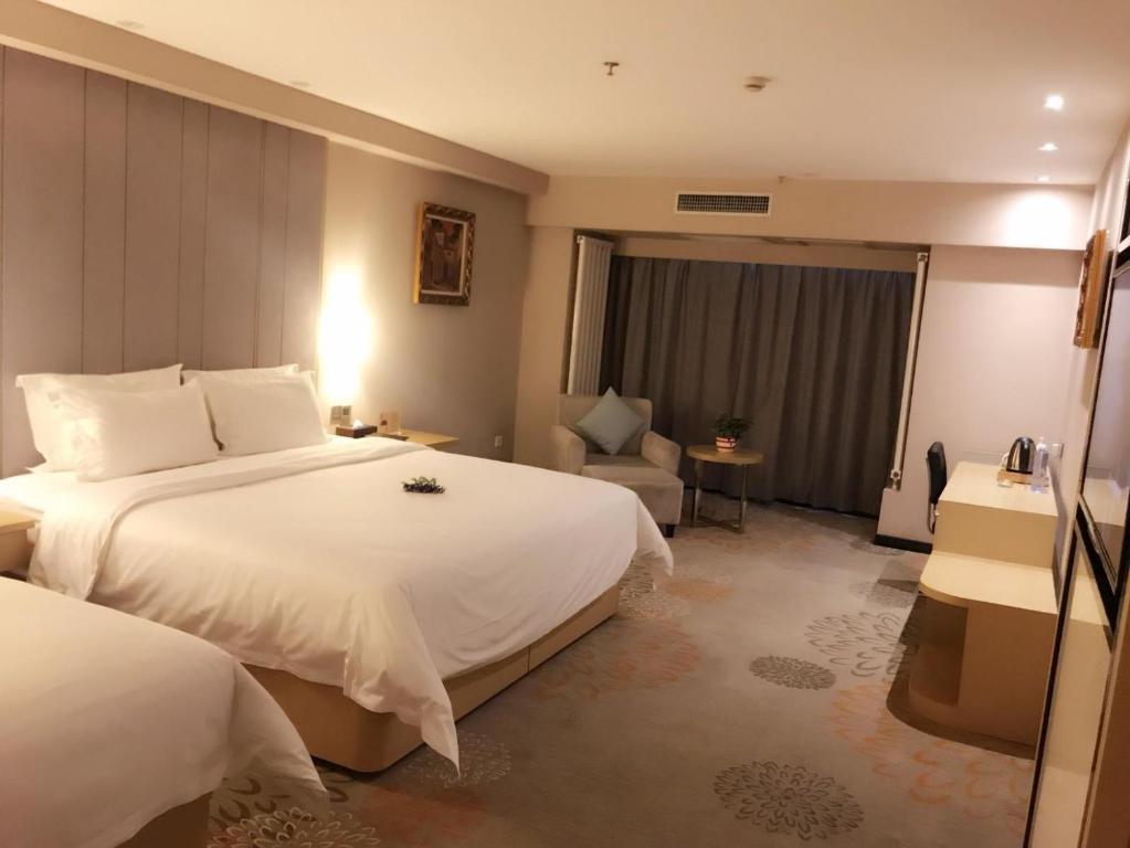 a hotel room with two beds and a chair at Lavande Hotel Yinchuan Wanda International Convention and Exhibition Center in Yinchuan
