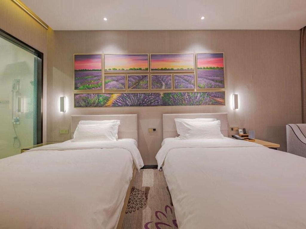 a hotel room with two beds and a painting on the wall at Lavande Hotel Ningbo Railway Station Branch in Ningbo