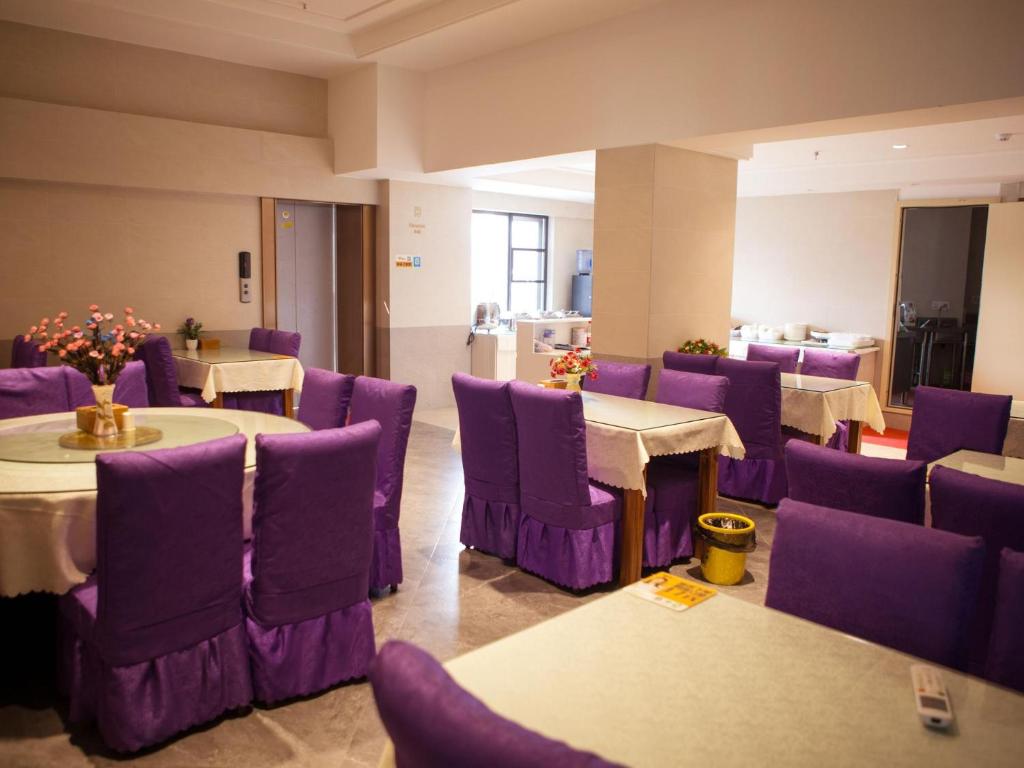 Shiyan的住宿－Lavande Hotel Shiyan Sanyan Branch，一间设有紫色椅子和一张桌子的房间和一间带桌子的房间