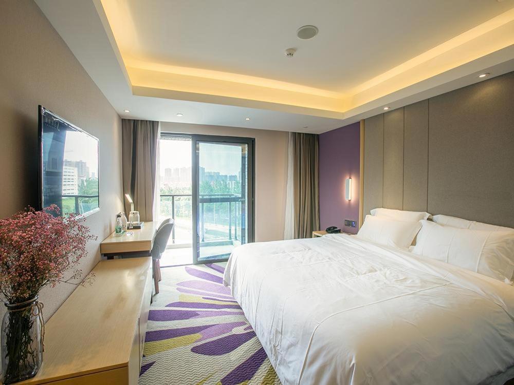 ein Schlafzimmer mit einem großen weißen Bett und einem Fenster in der Unterkunft Lavande Hotel (Nanchang Qianhu Avenue Nanchang Univercity Branch) in Nanchang