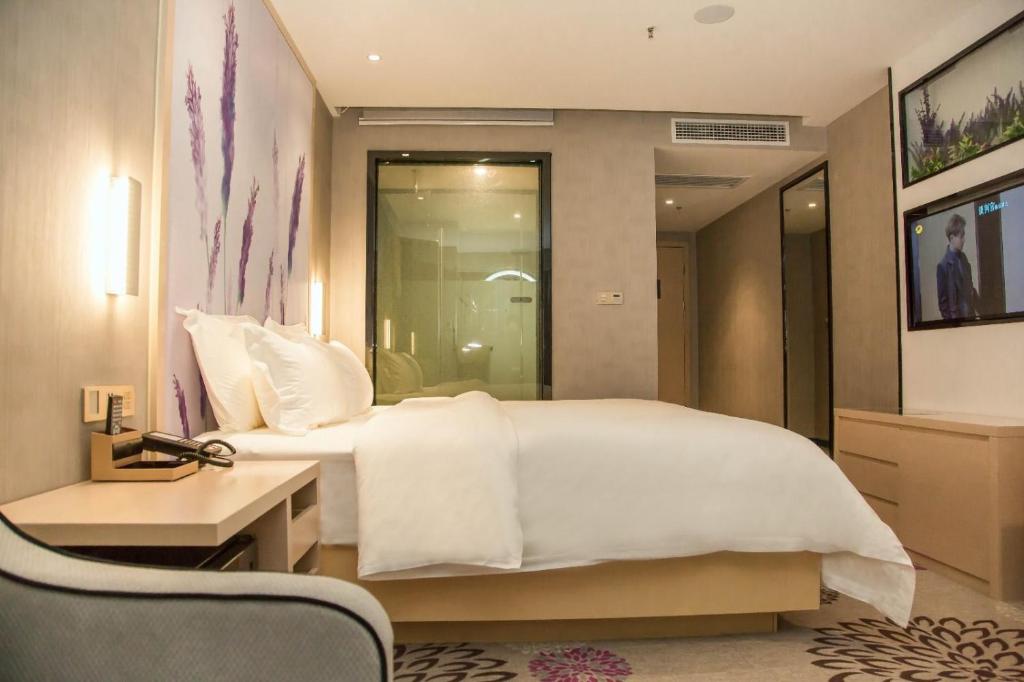 um quarto com uma grande cama branca e uma secretária em Lavande Hotels Xianning Tonghui Square Branch em Xianning