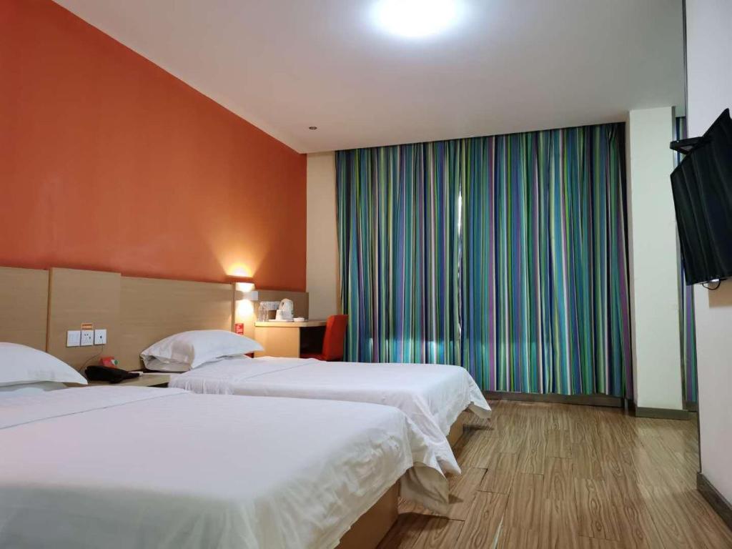 a hotel room with two beds and a large window at 7Days Inn Yongzhou Central Hospital in Yongzhou