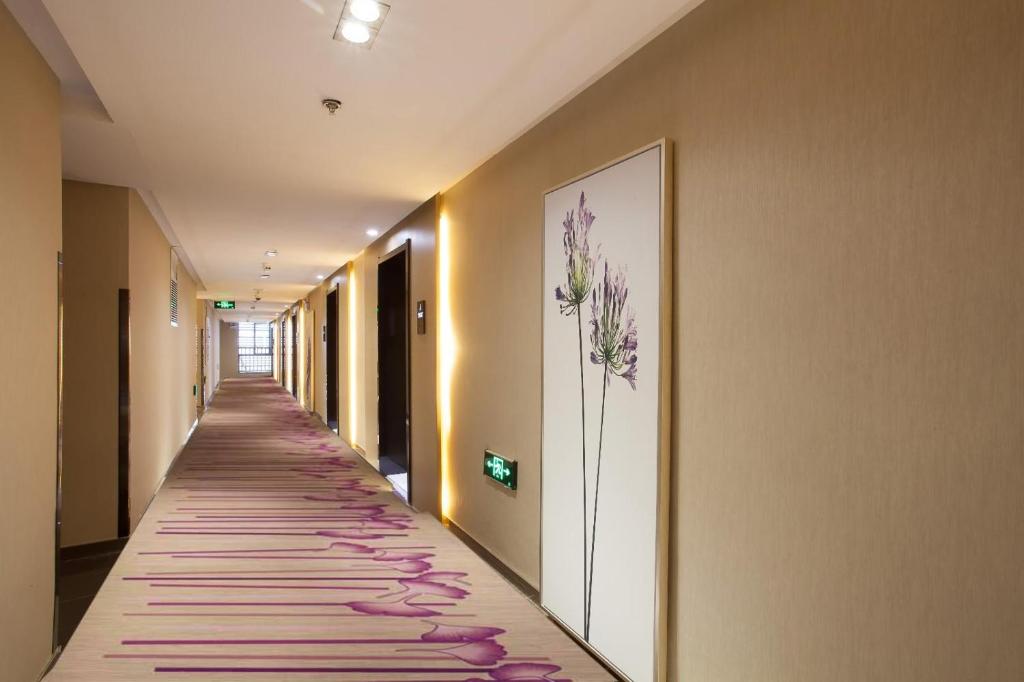 a hallway with a long aisle with flowers on the wall at Lavande Hotel Xuzhou West Exit of High Speed Rail Station Branch in Xuzhou