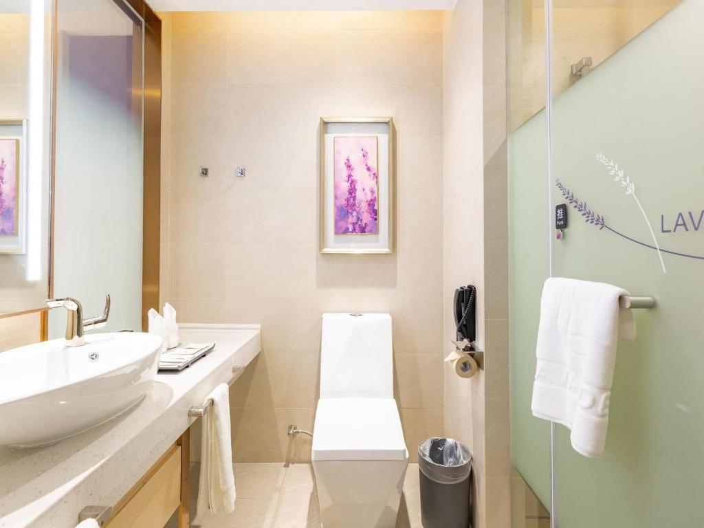 Baño blanco con lavabo y espejo en Lavande Hotel Nanchang Qingyunpu Zhuqiao East Road, en Nanchang
