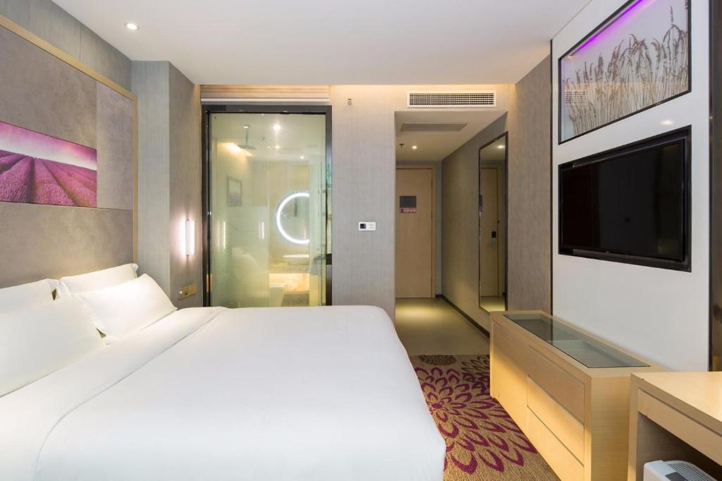a bedroom with a large white bed and a tv at Lavande Hotel Changsha Pedestrian Street Nanmenkou Metro Station Branch in Changsha