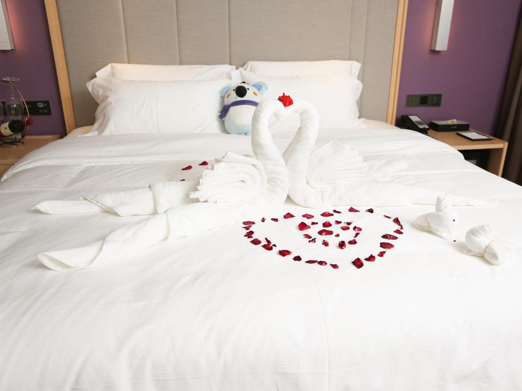 dwa łabędzie zrobione z serc na łóżku w obiekcie Lavande Hotel Zhoushan Putuo w mieście Zhoushan