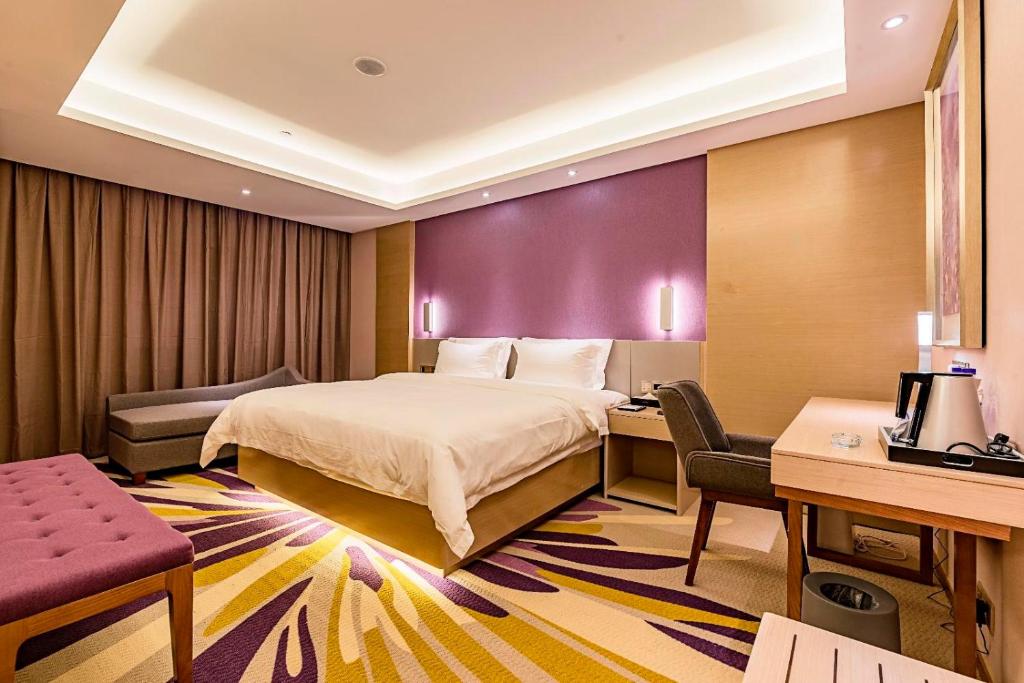 een hotelkamer met een bed en een bureau bij Lavande Hotel (Qinhuangdao Yingbin Road Railway Station Branch) in Qinhuangdao