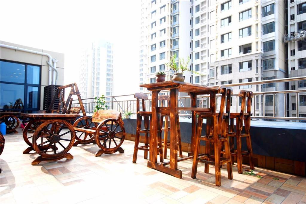 eine Gruppe von Holztischen und -stühlen auf einem Balkon in der Unterkunft Lavande Hotel Rizhao Rong'an Square Wanda Movie Theater Branch in Rizhao