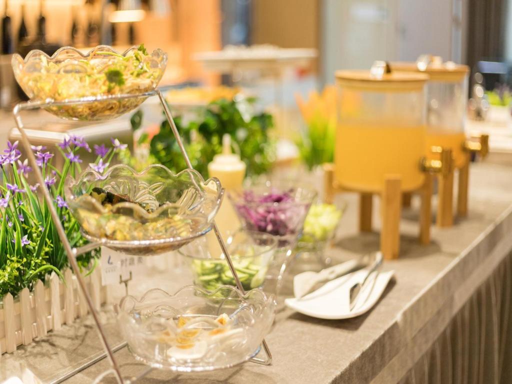 uma mesa coberta com tigelas e pratos de plantas em Lavande Hotel Cangzhou Kaiyuan Avenue Rongsheng Plaza em Cangzhou