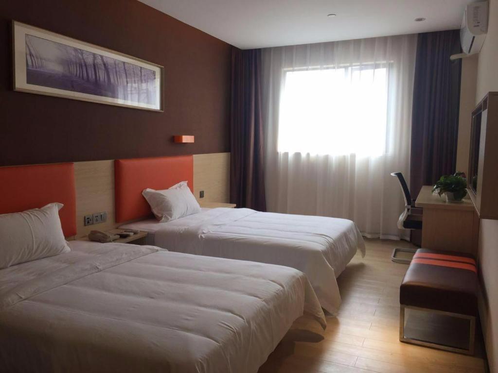 pokój hotelowy z 2 łóżkami i oknem w obiekcie 7 Days Premium Jiaozuo Renmin Road Teachers College w mieście Jiaozuo