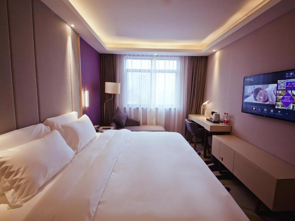 Lavande Hotel (Changsha Railway Station Branch) في تشانغشا: غرفة فندق بسرير كبير وتلفزيون