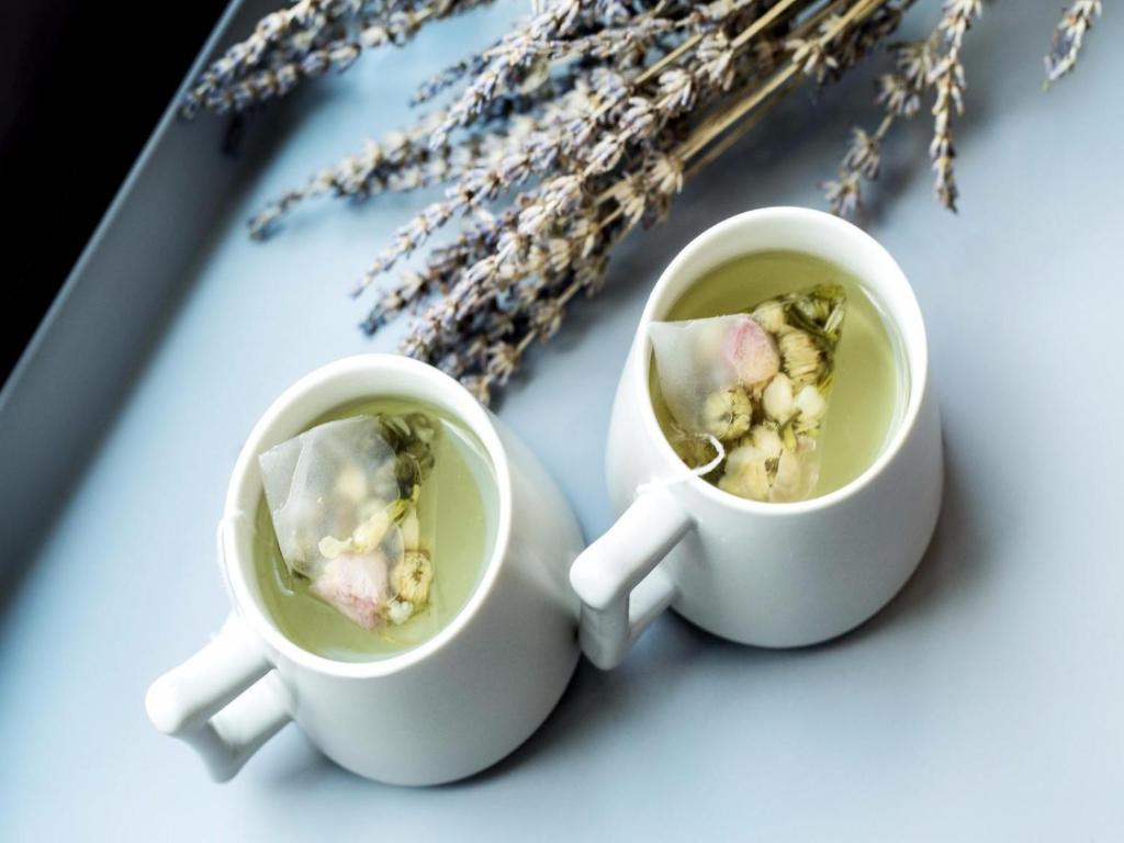 two white cups of coffee and some dried flowers at Lavande Hotel Xianyang Yuquan Road Wanda Plaza Branch in Xianyang