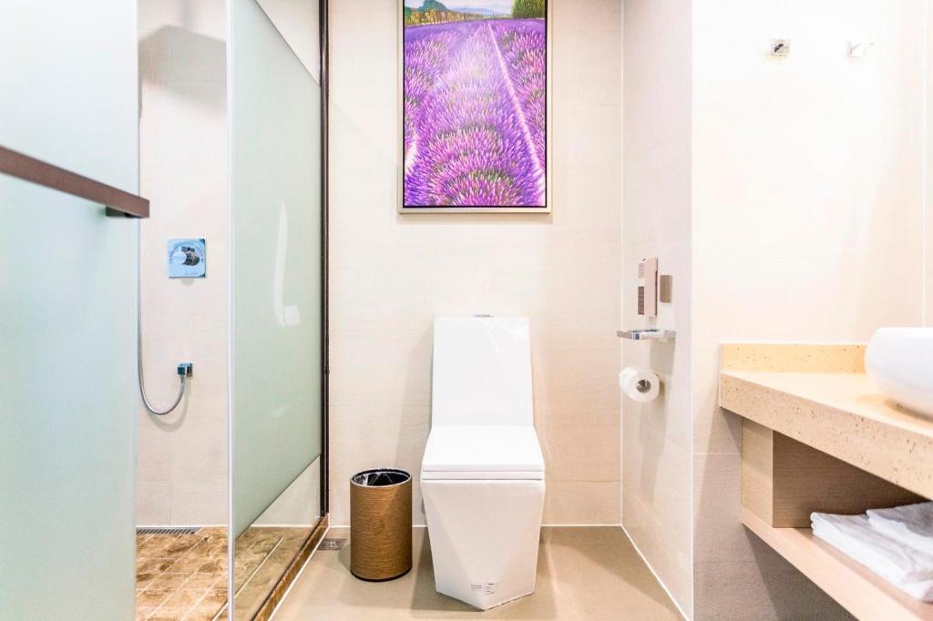 uma casa de banho com um WC e uma cabina de duche em vidro. em Lavande Hotel Nanchang Qingshanhu Wanda Branch em Nanchang