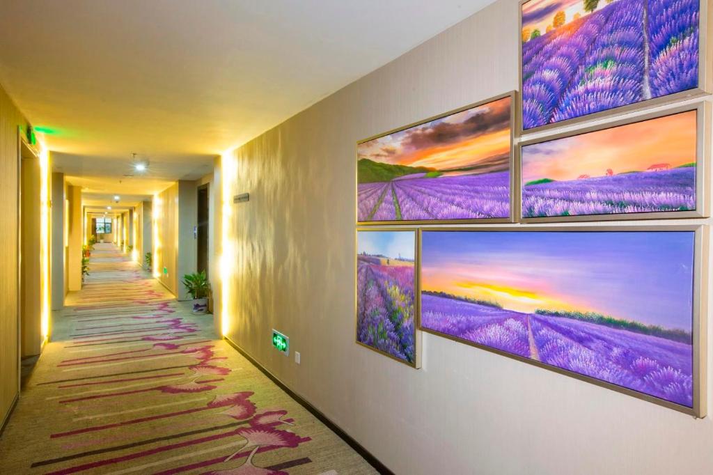 a hallway with several paintings on the wall at Lavande Hotel Nanchang West Railway Station Xinjian Branch in Nanchang