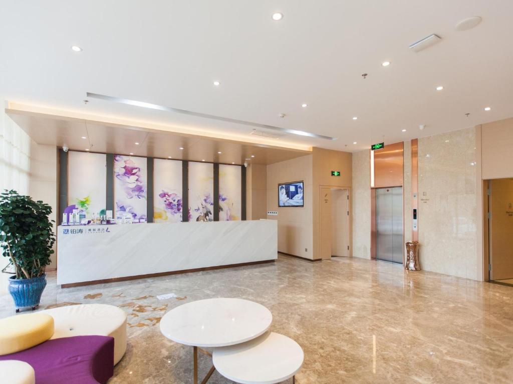 a large lobby with two tables and a counter at Lavande Hotel (Chengde Mountain Resort Waiba Temple Branch) in Chengde