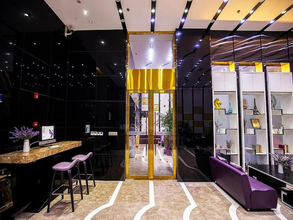 a lobby with a yellow door and purple stools at Lavande Hotel Leshan High-speed Railway Station Wanda Plaza in Leshan