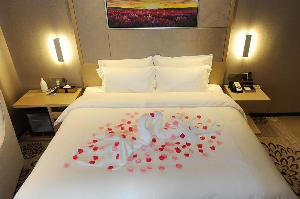 um quarto de hotel com uma cama com um cisne em Lavande Hotel Changde Railway Station Branch em Changde