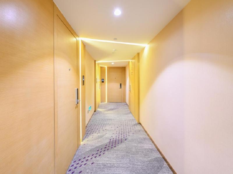 a corridor of a hallway with a long hallway at Lavande Hotel (Shenyang Olympic Center Wanda Branch) in Shenyang