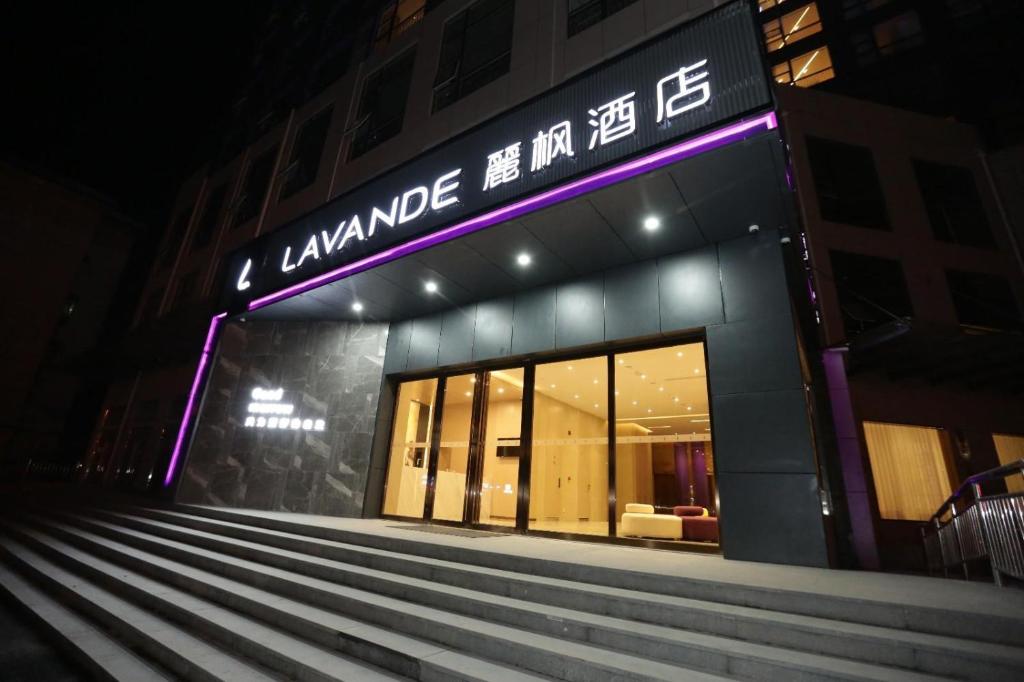 a building with a purple sign on the front of it at Lavande Hotel (Jingdezhen Taoxichuan Creative Square Branch) in Jingdezhen