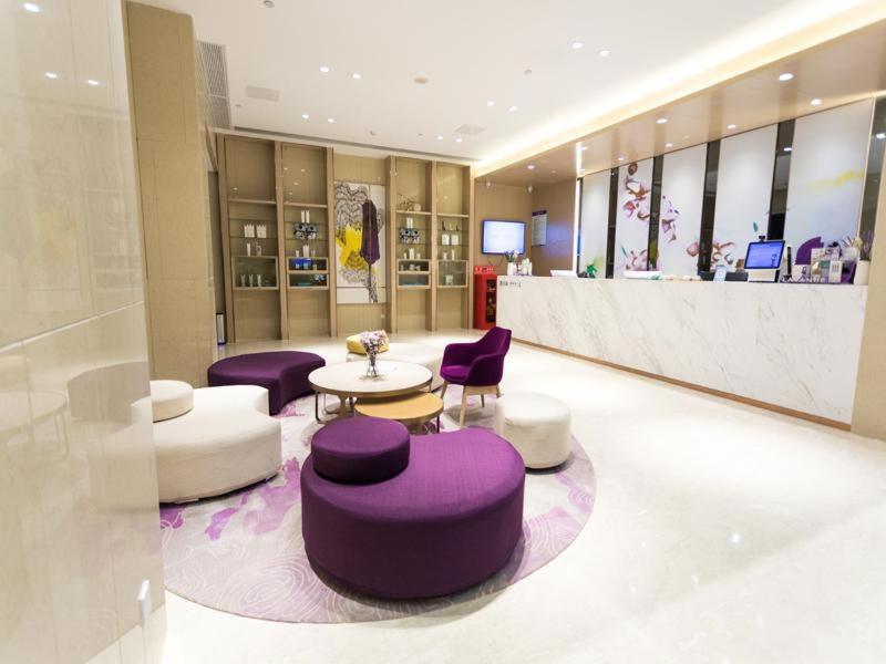 a lobby with purple chairs and tables and a counter at Lavande Hotel Suqian Yanghe New District in Suqian