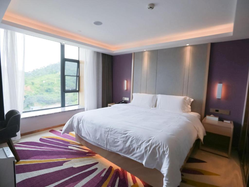 sypialnia z dużym łóżkiem i dużym oknem w obiekcie Lavande Hotel (Gaozhou Chengdong Bus Station Branch) w mieście Maoming
