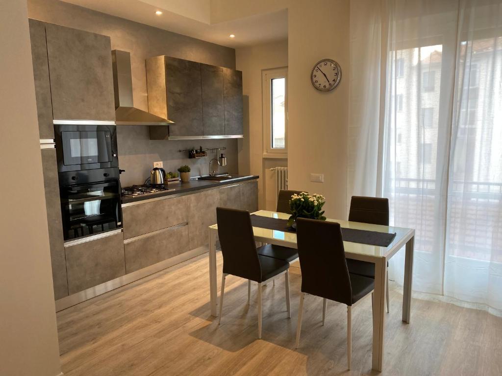 a kitchen with a table and chairs and a clock at Residenza Bonomi 23 in Mantova