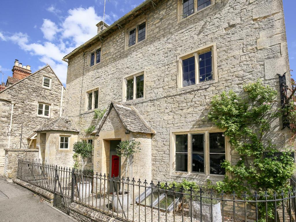 an old stone house with a red door at The Old Post Office in Cirencester