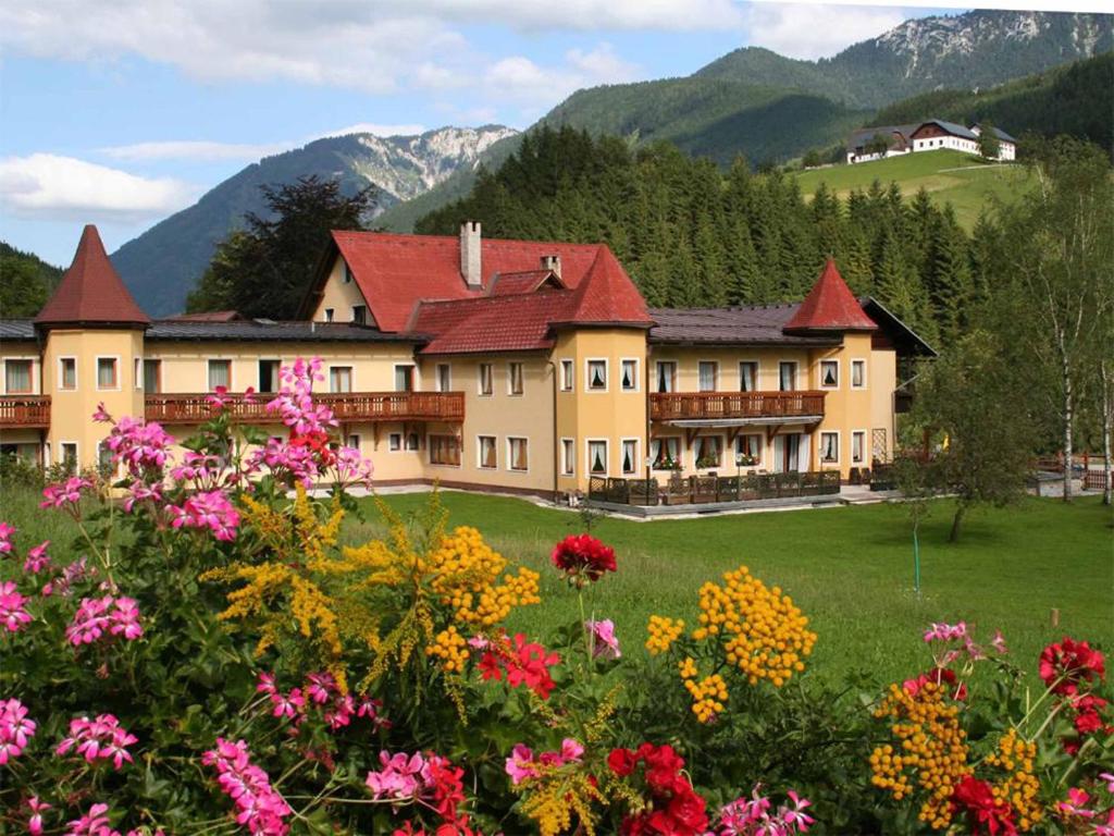a large building in a field with flowers at Hotel Waldesruh in Göstling an der Ybbs