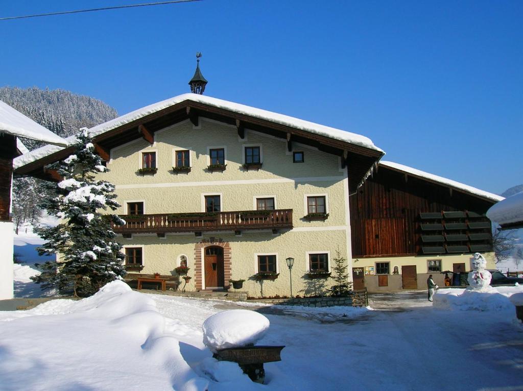 ein großes Gebäude mit Schnee auf dem Boden davor in der Unterkunft Palfnerhof Appartements in St. Johann im Pongau