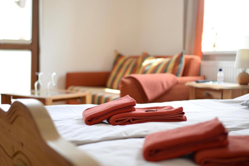 a bed with two red towels on top of it at Gasthaus & Pension Zirkelstein in Schöna