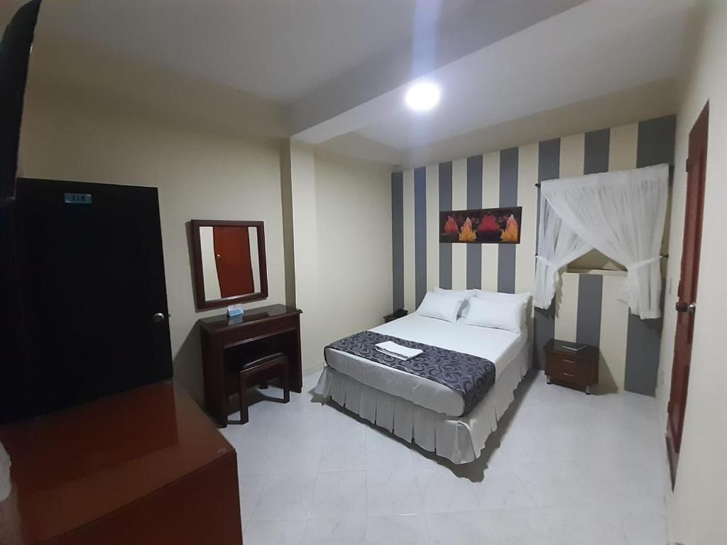 a hotel room with a bed and a mirror at Hotel El Andino in Cúcuta