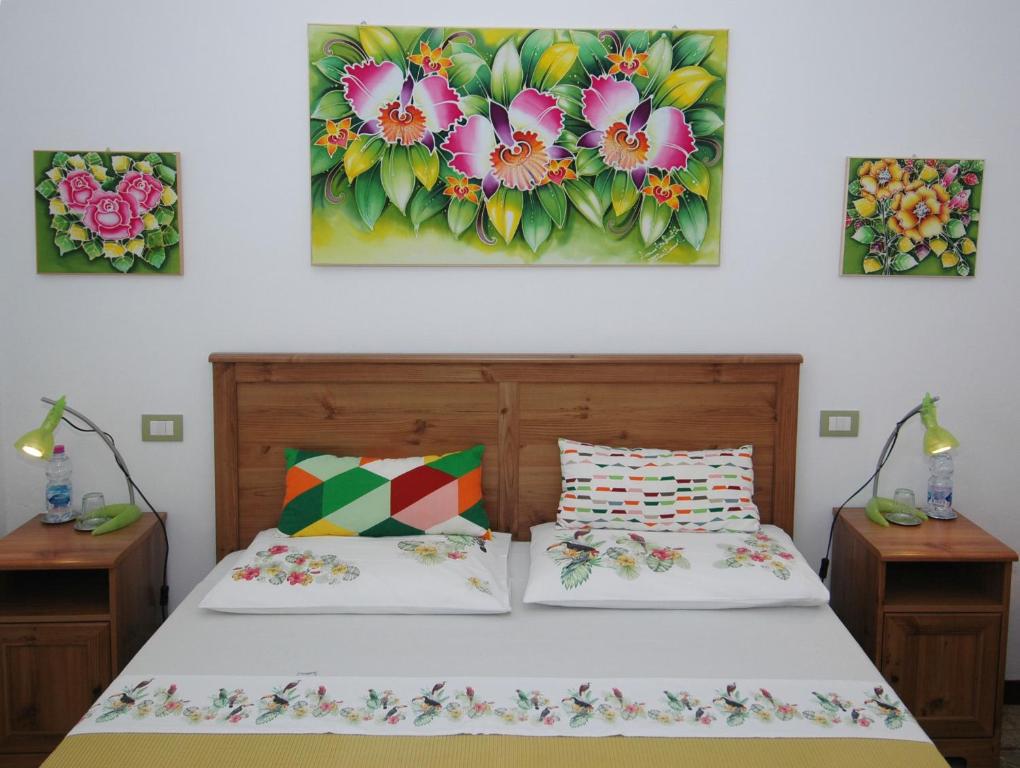 シエナにあるB&B Casa Certosaのベッドルーム1室(ベッド2台付)が備わります。壁には絵画が2点飾られています。