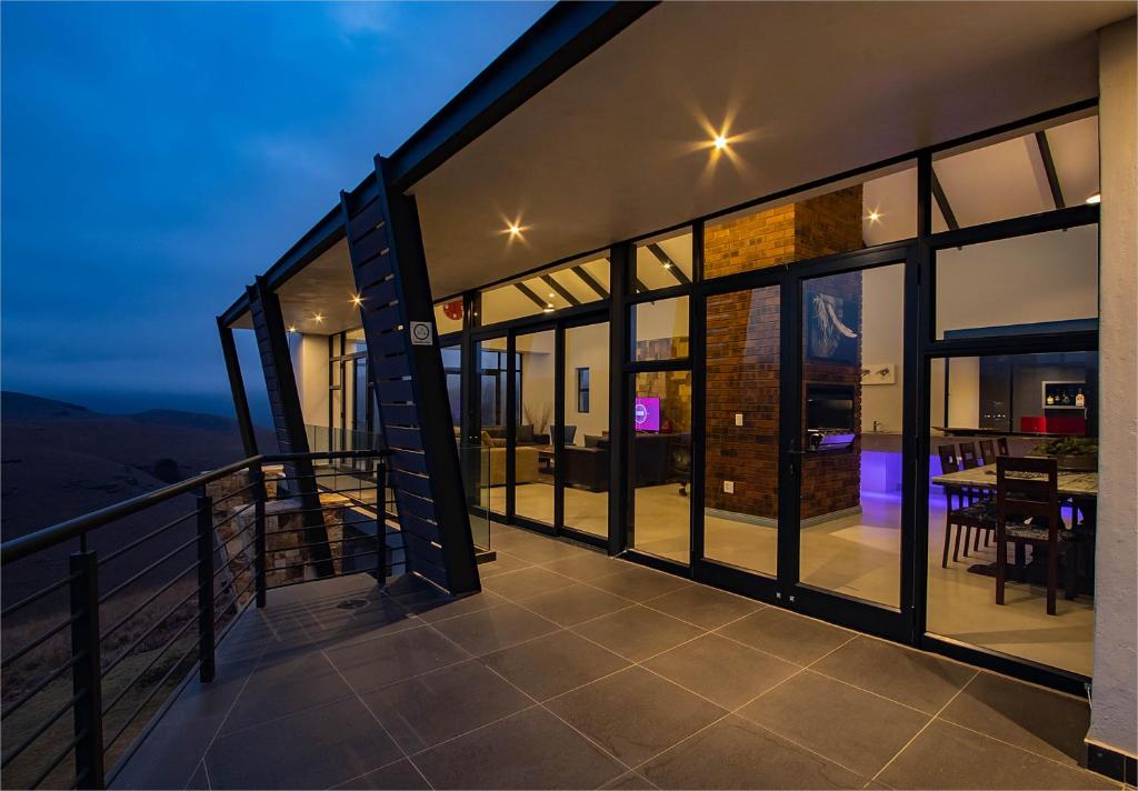 un balcón de una casa con ventanas de cristal en Highland Gate Golf Retreat, en Dullstroom