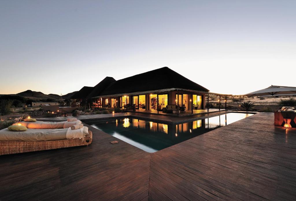 a villa with a swimming pool in the desert at Sandfontein Lodge & Nature Reserve in Sandfontein