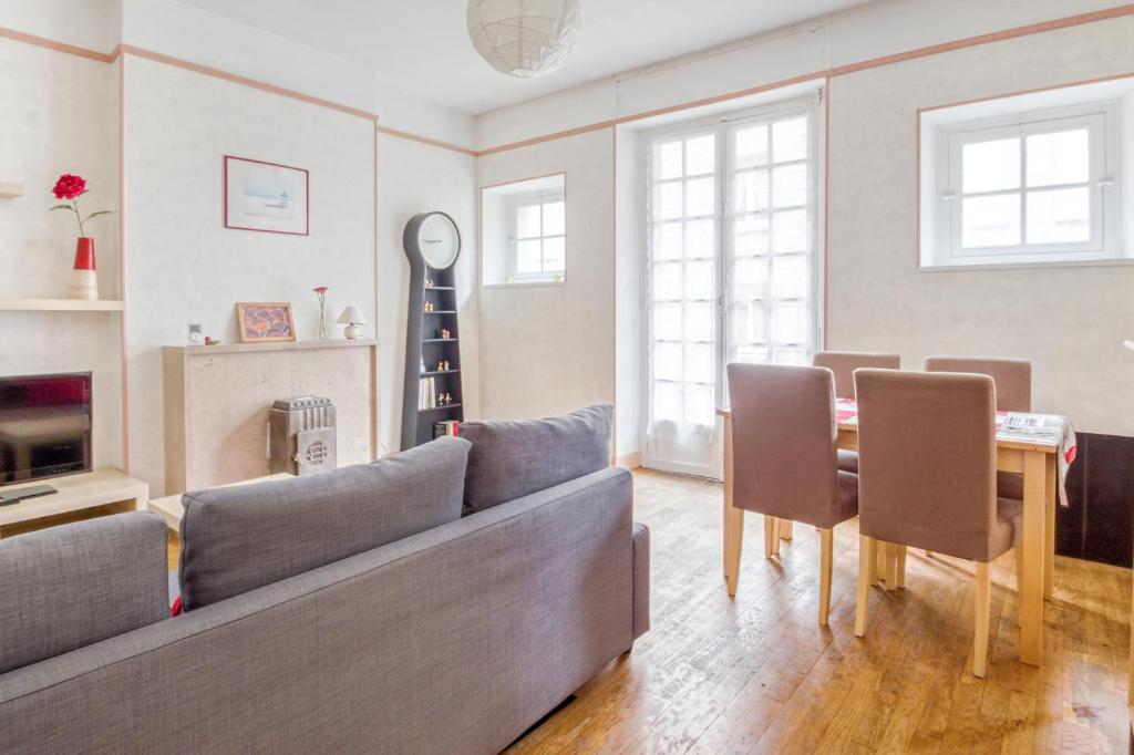 a living room with a couch and a table at Ermine - Intramuros proche plage - St Malo in Saint Malo