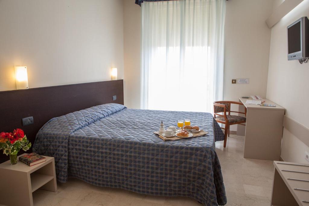 a hotel room with a bed, desk, chair, and lamp at AUTO PARK HOTEL con Ristorante interno e grande parcheggio gratuito in Florence