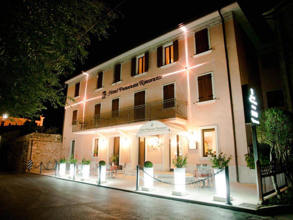 un edificio bianco con luci accese di notte di Hotel Panorama Ristorante ***S a Torri del Benaco