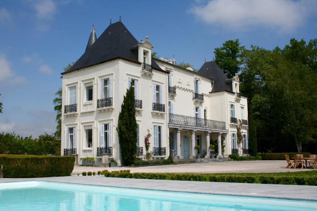 a large white house with a swimming pool in front of it at Chateau Mont Joly in Gan