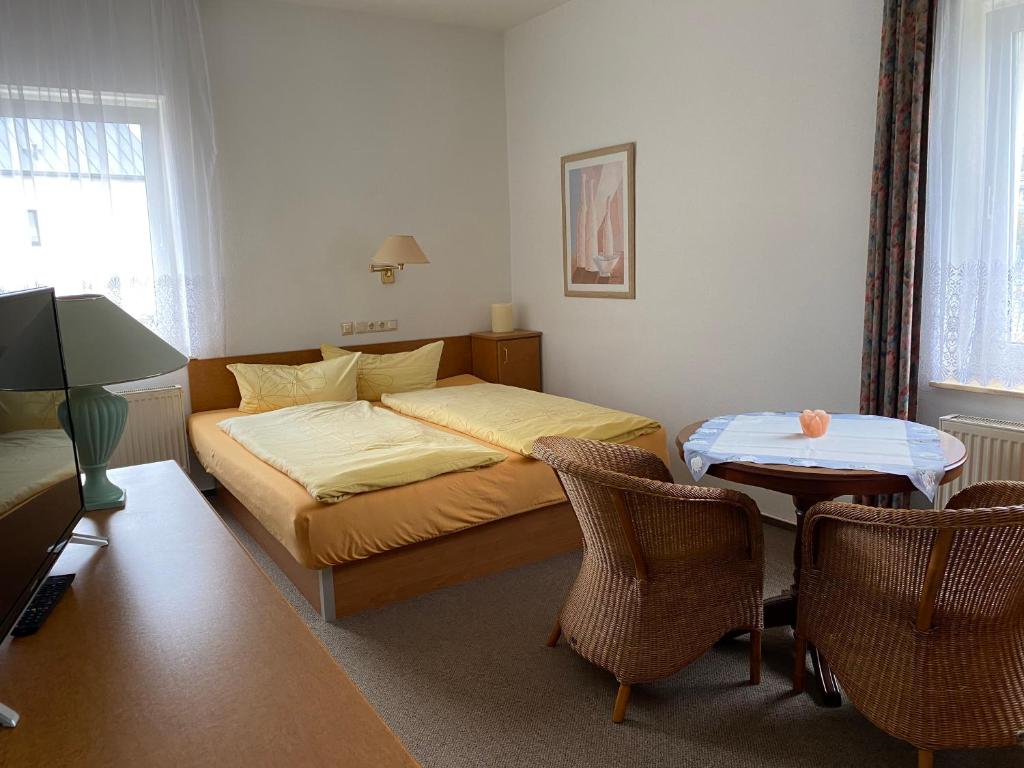 a bedroom with a bed and a table and chairs at 28 qm Apartments am Rosengarten in Bad Elster