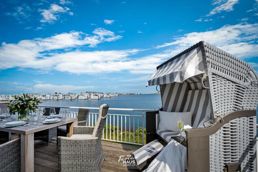 a balcony with a table and chairs and the ocean at Traumfänger in Olpenitz