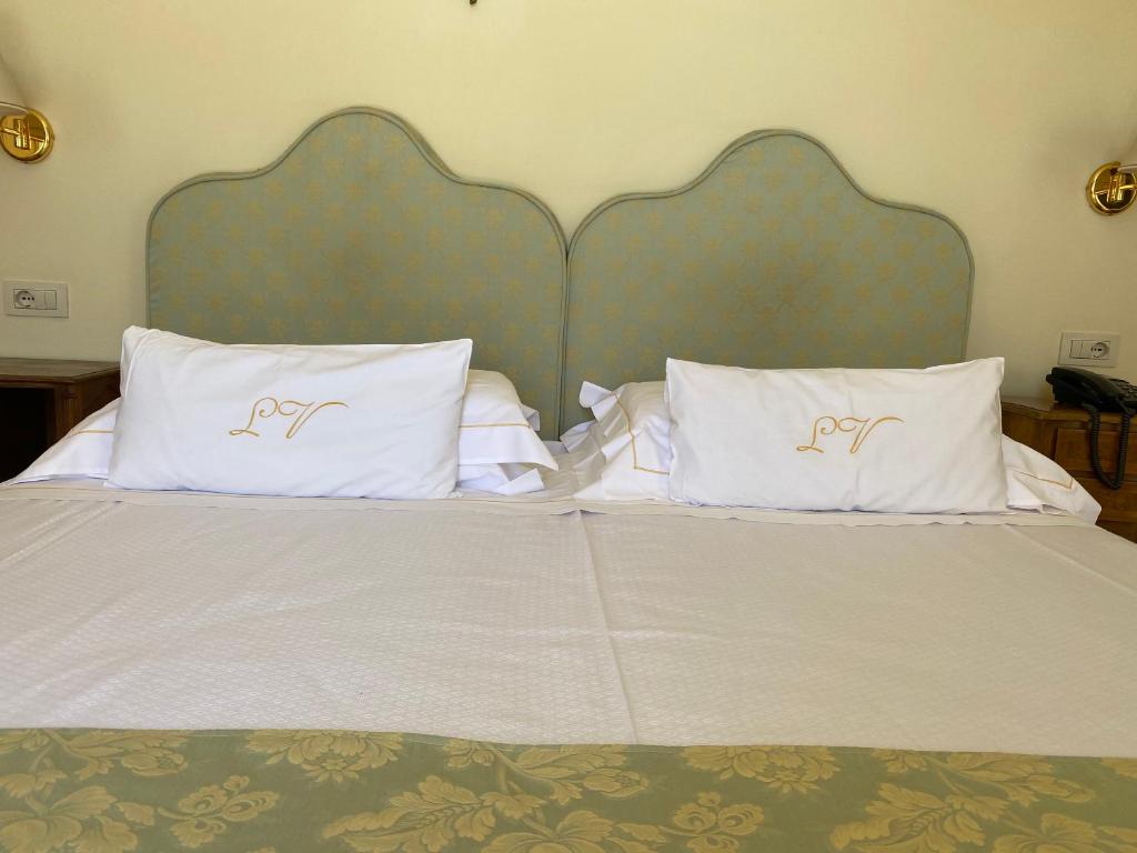 A bed or beds in a room at La Vittoria Boutique Hotel